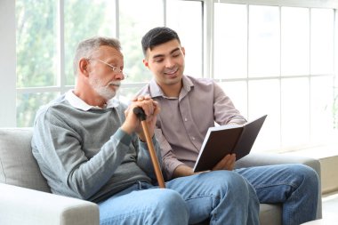 Evde oğlu ve fotoğraf albümüyle kıdemli bir adam var.