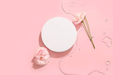 Alçı podyum ve pembe arka planda suda güzel Eustoma çiçekleri.