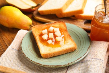 Lezzetli armut reçelli tabak ve ahşap zemin üzerinde ekmek.