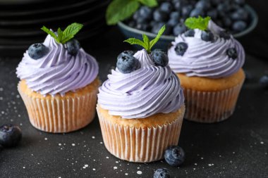 Böğürtlenli lezzetli kekler ve siyah arkaplanda nane şekeri.