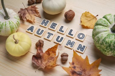 Meşe palamudu, yaprak ve yazılı balkabakları Kahverengi ahşap arka planda Hello AUTUMN