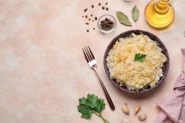 Lezzetli lahana turşulu kase ve pembe arka planda baharatlar.