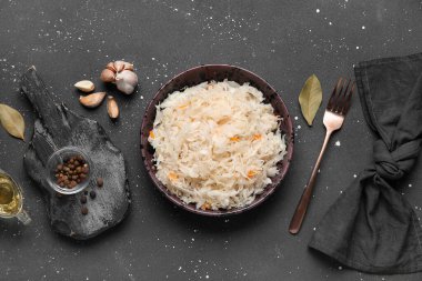 Lezzetli lahana turşulu kase ve siyah arka planda farklı baharatlar.