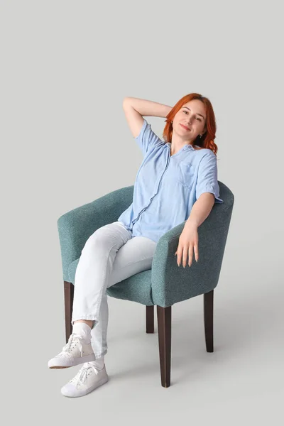 Młoda Kobieta Siedzi Miękkim Fotelu Jasnym Tle — Zdjęcie stockowe