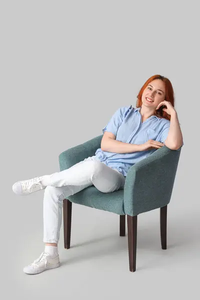 Młoda Kobieta Siedzi Miękkim Fotelu Jasnym Tle — Zdjęcie stockowe