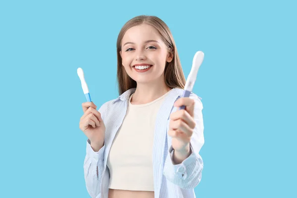 Gelukkig Jong Vrouw Met Positieve Zwangerschapstesten Blauwe Achtergrond — Stockfoto