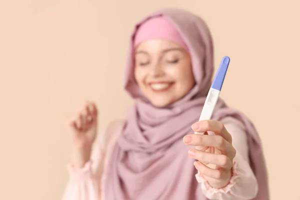 Glückliche Junge Muslimin Mit Schwangerschaftstest Auf Beigem Hintergrund — Stockfoto