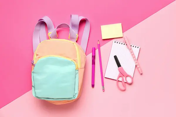 不同粉红背景文具用品的时尚校服背包 — 图库照片