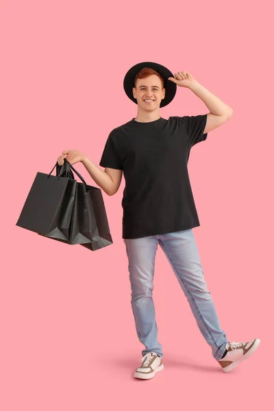 Šťastný Mladý Zrzek Muž Nákupními Taškami Růžovém Pozadí Černý Pátek — Stock fotografie