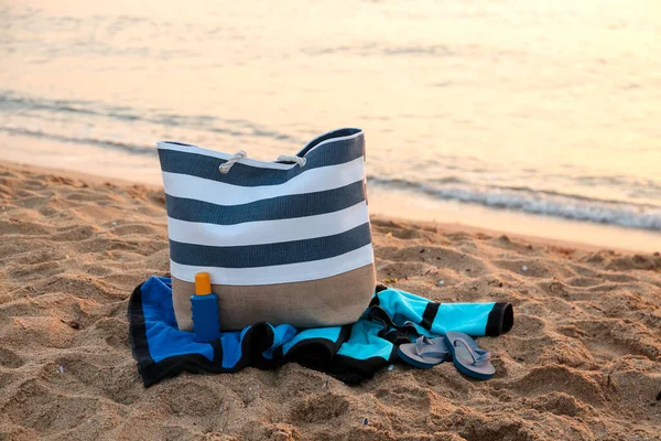 Stylish Beach Bag Flip Flops Sunscreen Cream Towel Sand Sea — Stock Photo, Image