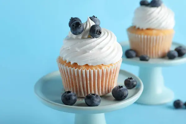 Stand Sabroso Cupcake Con Arándanos Sobre Fondo Azul —  Fotos de Stock