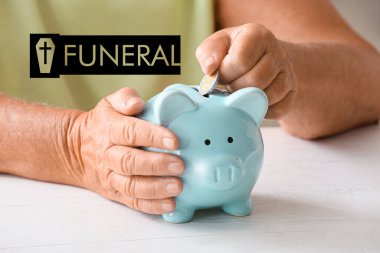 Kıdemli kadın masadaki kumbaraya para koyuyor. Cenaze için para biriktirme