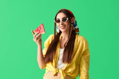 Yeşil arka planda taze karpuz olan genç bir kadın.