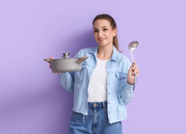 Leylak arka planında kepçe ve tavuk çorbası olan genç bir kadın.