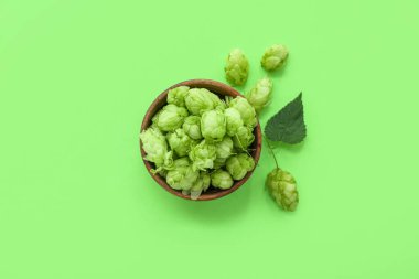 Taze yeşil zıpzıp ve arka planda yaprak olan ahşap kase.