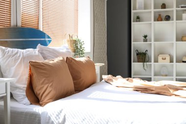 Pencere kenarında sörf tahtası olan aydınlık yatak odasının içi