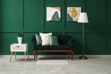 Oturma odasının içinde kanepe, lamba ve masa var.