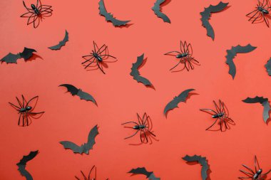 Kırmızı arka planda Cadılar Bayramı partisi için kağıt yarasalar ve örümcekler.