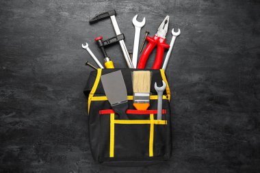 Siyah arkaplanda farklı inşaat araçlarına sahip kemer