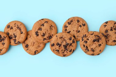 Mavi arka planda çikolata parçacıklı lezzetli kurabiyeler.