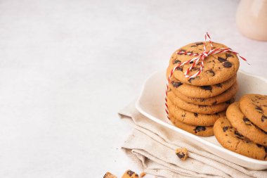 Beyaz arka planda çikolata parçacıklı bir kase lezzetli kurabiye.