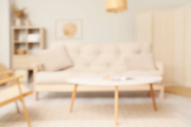 Beyaz kanepe ve kahve sehpası ile oturma odası manzarası bulanık.