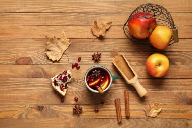 Portakallı sıcak şarap ve ahşap zemin üzerinde nar.