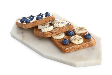 Fıstık ezmeli tost tahtası ve beyaz arka planda taze meyve.