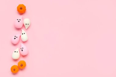 Pembe arka planda hayaletler ve balkabaklarıyla Cadılar Bayramı kompozisyonu