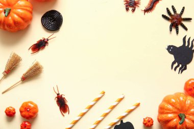 Cadılar Bayramı şeker böceklerinden, balkabaklarından ve bej arkaplanda süpürgelerden yapılmış çerçeve