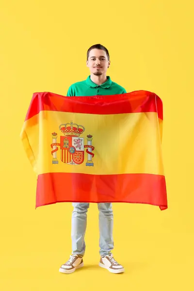 Przystojny Młody Człowiek Flagą Hiszpanii Żółtym Tle — Zdjęcie stockowe
