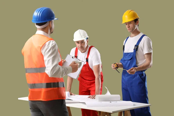 Team Männlicher Bauarbeiter Mit Tisch Auf Grünem Hintergrund — Stockfoto