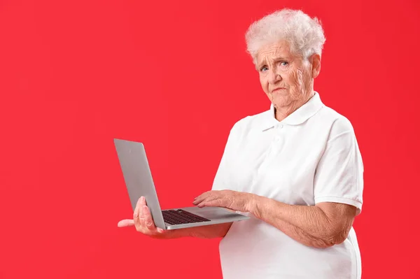 Старша Жінка Використовує Ноутбук Червоному Тлі — стокове фото