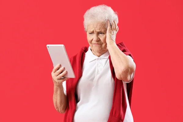 Mulher Sênior Perturbado Usando Computador Tablet Fundo Vermelho — Fotografia de Stock