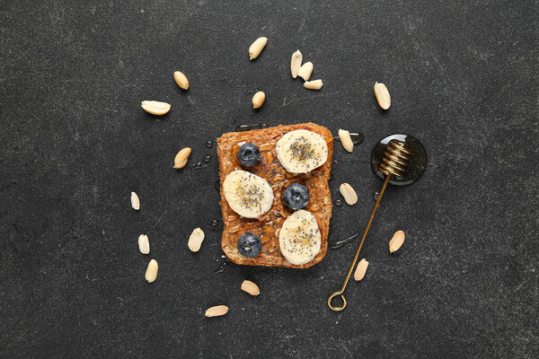 Тост с арахисовым маслом, свежие фрукты и мед на черном фоне