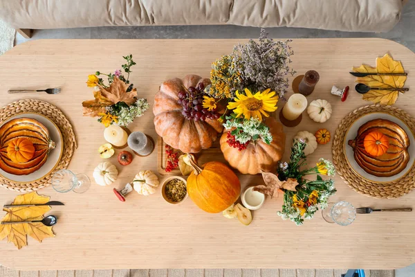 部屋のダイニングテーブルにカボチャと花が付いた秋の設定 トップビュー — ストック写真