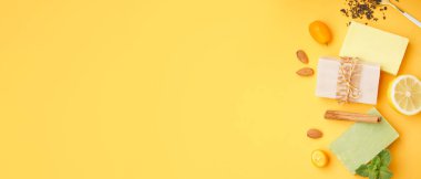 Metin ve üst görünüm için alanı olan sarı arkaplan üzerindeki sabun çubukları ve doğal malzemelerle kompozisyon