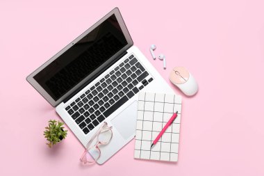 Dizüstü bilgisayarlı, gözlüklü ve pembe arka planda not defteri olan kompozisyon