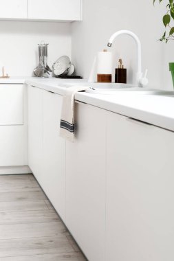 Mutfakta lavabo ve çatal bıçak olan beyaz tezgahlar.