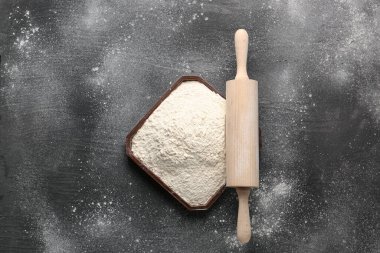 Buğday unlu tabak ve grunge siyah arkaplanda merdane.