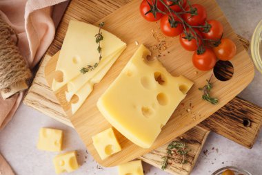Beyaz masada İsviçre peyniri ve domates parçaları olan tahtalar.