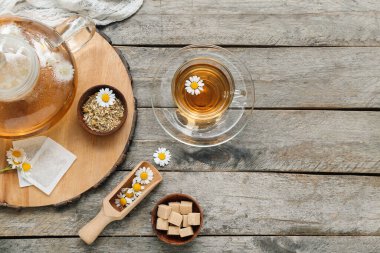 Tahta arka planda bir fincan sıcak papatya çayı.