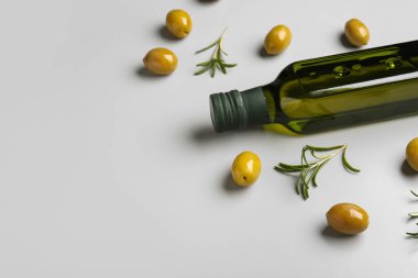 Gri arka planda bir şişe zeytinyağı