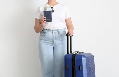 Bavulu, pasaportu, bileti ve parası olan genç bir kadın. Seyahat kavramı