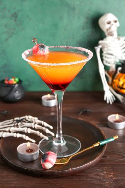 Cadılar Bayramı için bir bardak lezzetli Margarita kokteyli ve masada mumlar.