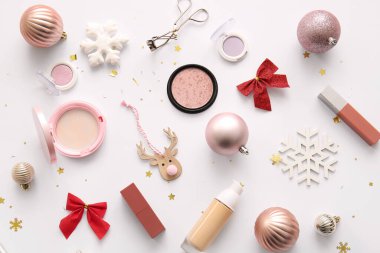 Dekoratif kozmetik ürünleri ve beyaz arka planda Noel dekoru olan kompozisyon