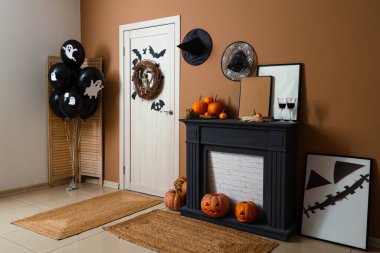 İçinde şömine, balon, kapı ve Cadılar Bayramı süslemeleri olan festival koridoru.