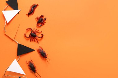 Turuncu arka planda şeker böcekleri ve çelenk olan Cadılar Bayramı kompozisyonu