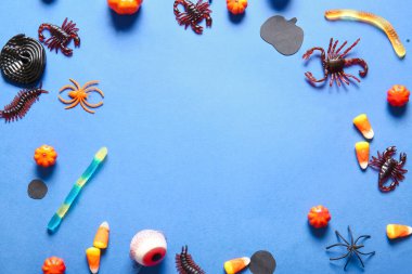 Cadılar Bayramı şeker böceklerinden yapılmış çerçeve ve mavi arka planda gözler