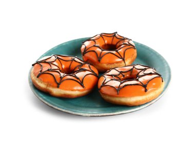 Beyaz arka planda Cadılar Bayramı için lezzetli çöreklerle dolu bir tabak.